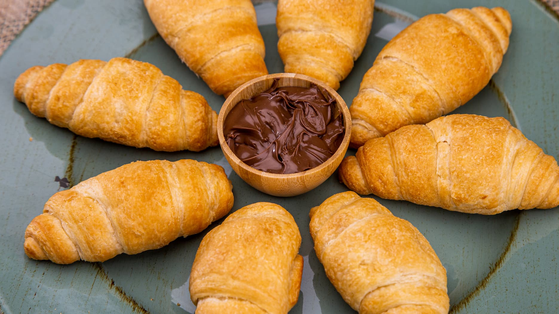 Pães sobre um cesto ao lado de uma xícara de café